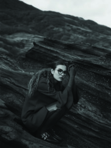 Jeune fille accroupie sur un rocher. Créateur de lunettes MATSUDA chez Eye-like