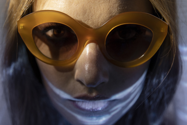 Visage proche d'une jeune femme sous l'eau avec des lunettes de soleil LAPIMA