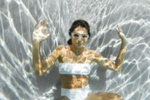 Portrait d'une jeune femme sous l'eau avec des lunettes de soleil LAPIMA
