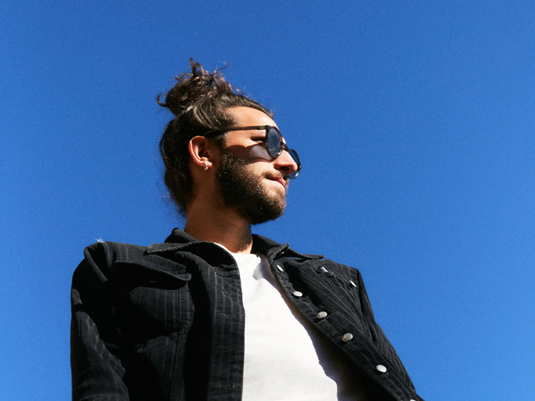 Modèle masculin portant des lunettes de soleil Baars Jim6 posé sur fond ciel bleu