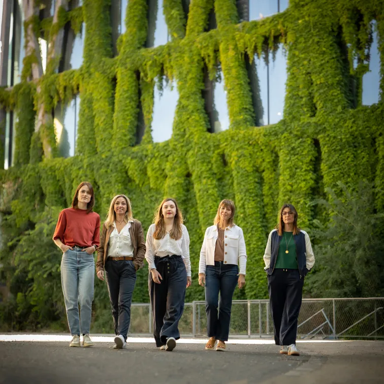 L'équipe des opticiennes de COnnivence en plein air, debout devant un mur végétal