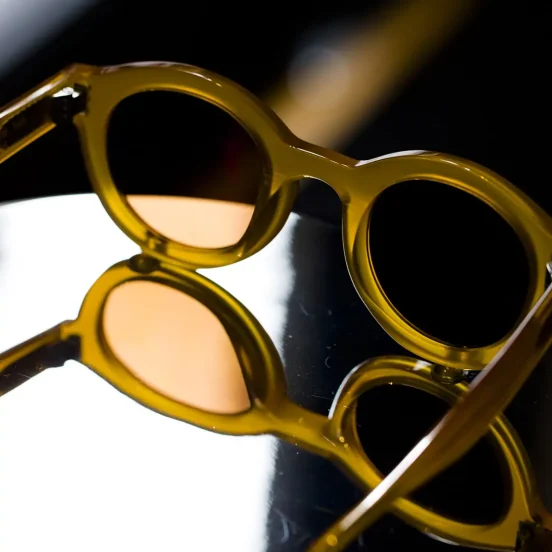 Photo de lunettes de marque posées sur une surface réfléchissante